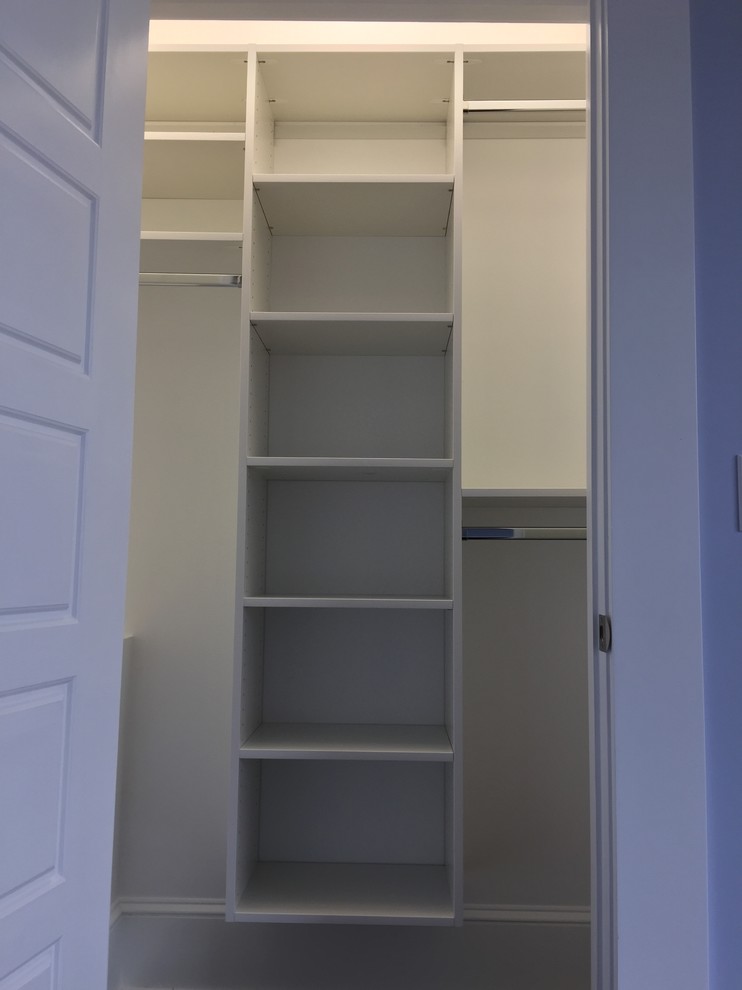 Modelo de armario unisex clásico pequeño con puertas de armario blancas y suelo de madera oscura