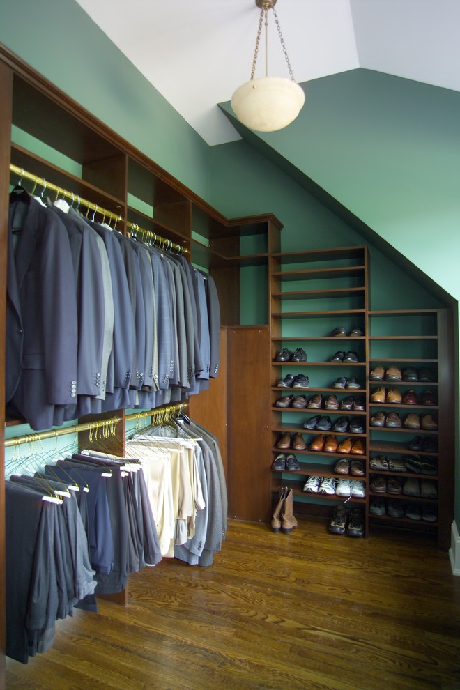 Modelo de armario vestidor de hombre tradicional grande con armarios abiertos, puertas de armario de madera oscura y suelo de madera en tonos medios