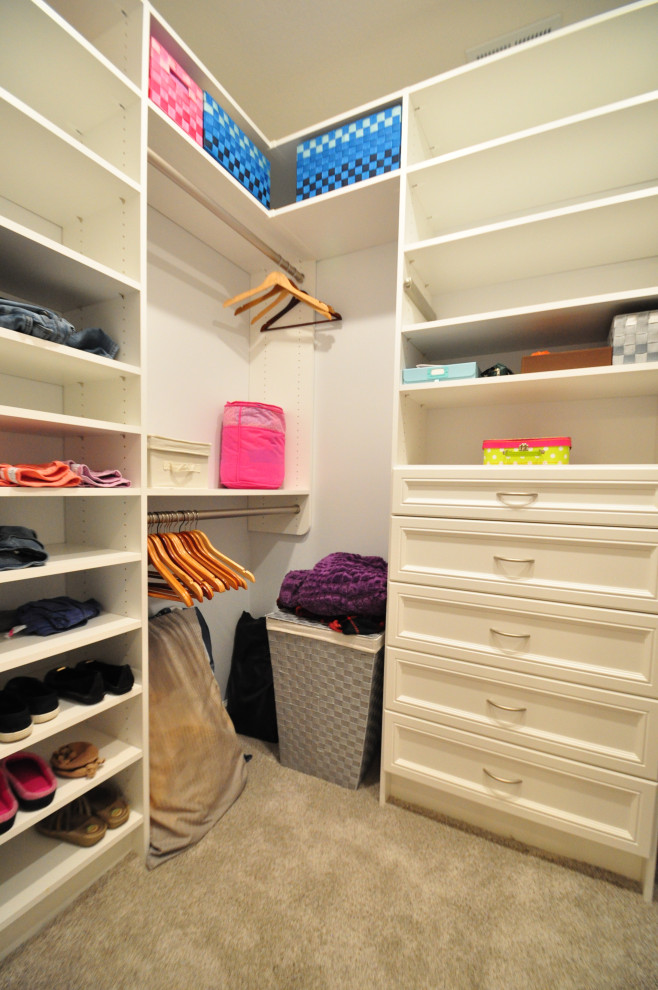 Modelo de armario vestidor unisex tradicional renovado de tamaño medio con armarios con paneles empotrados, puertas de armario blancas, moqueta y suelo beige
