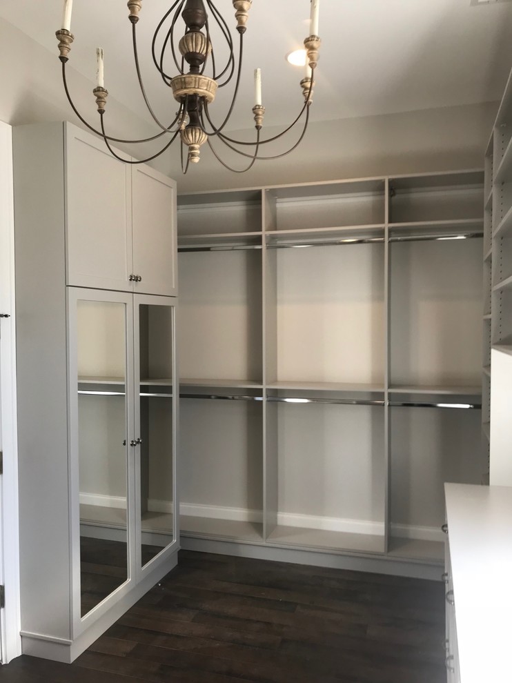 This is an example of a small contemporary gender neutral walk-in wardrobe in Other with shaker cabinets, grey cabinets, dark hardwood flooring and brown floors.