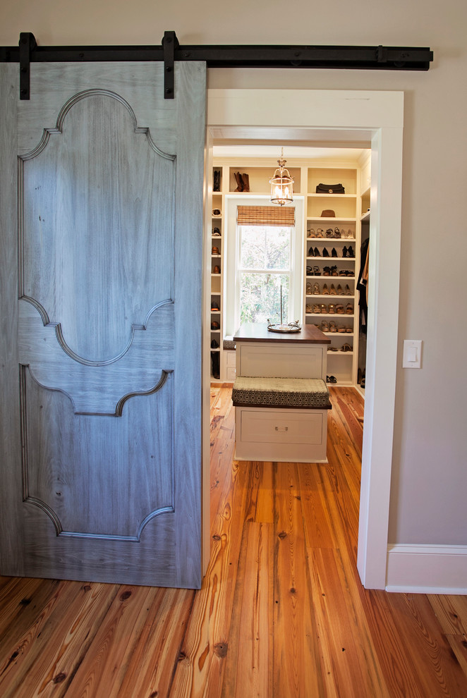 Ejemplo de vestidor unisex clásico renovado de tamaño medio con puertas de armario blancas, suelo de madera en tonos medios y armarios estilo shaker