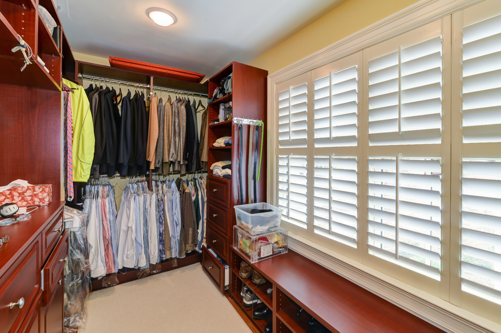 Inspiration for a medium sized classic walk-in wardrobe for men with beaded cabinets, dark wood cabinets and carpet.
