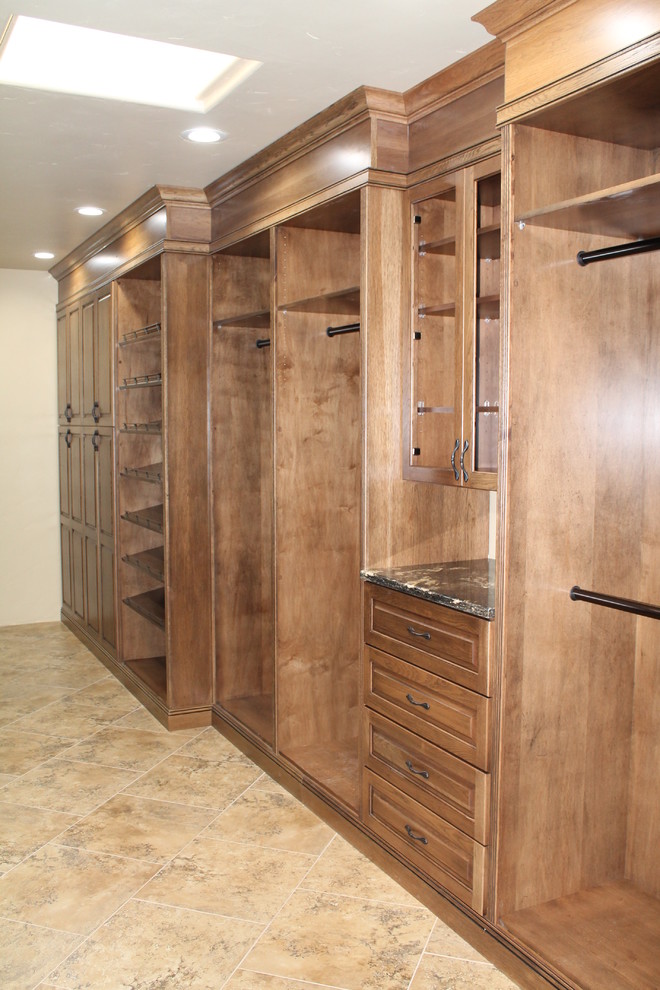 Inspiration for a large mediterranean gender-neutral ceramic tile walk-in closet remodel in Austin with raised-panel cabinets and medium tone wood cabinets