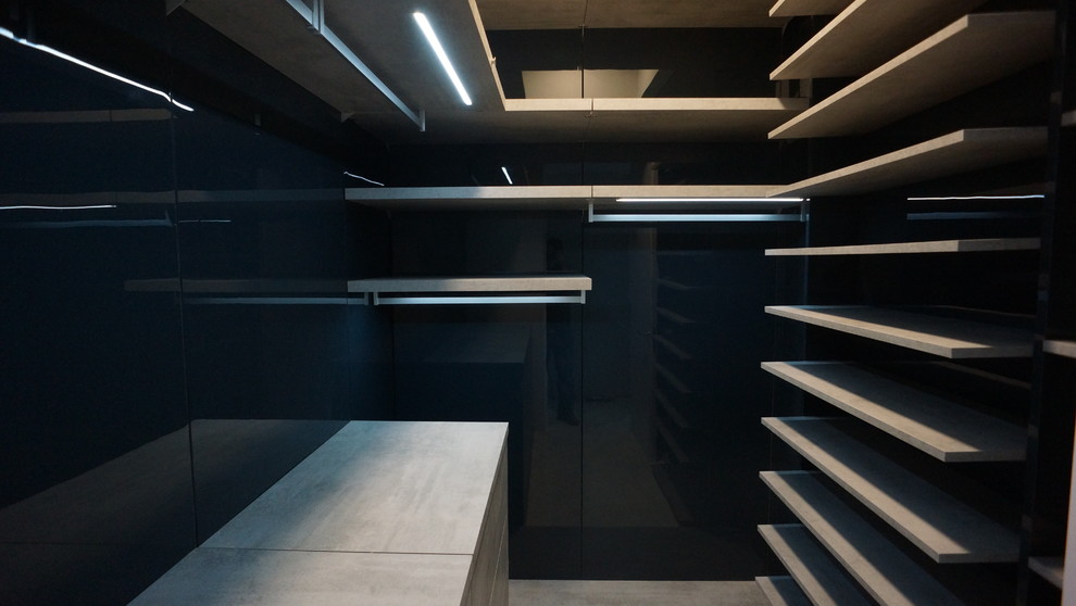 Immagine di una piccola cabina armadio unisex minimalista con ante lisce e ante grigie