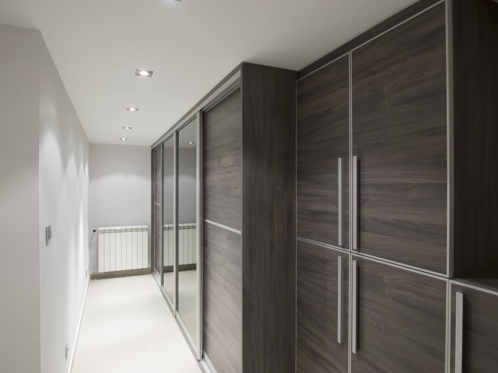Immagine di uno spazio per vestirsi unisex moderno di medie dimensioni con ante in legno bruno, moquette e pavimento beige