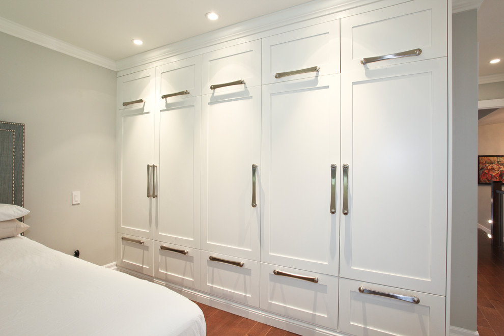 Foto di uno spazio per vestirsi unisex minimal di medie dimensioni con ante in stile shaker, ante bianche e pavimento in legno massello medio
