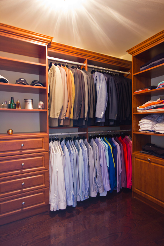 Walk-in closet - mid-sized traditional gender-neutral dark wood floor walk-in closet idea in New York with open cabinets and medium tone wood cabinets