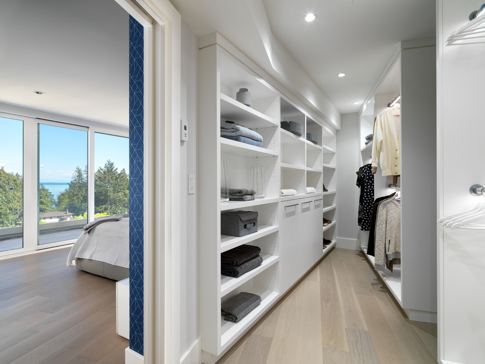 Идея дизайна: гардеробная комната унисекс в современном стиле с открытыми фасадами, белыми фасадами, светлым паркетным полом и бежевым полом