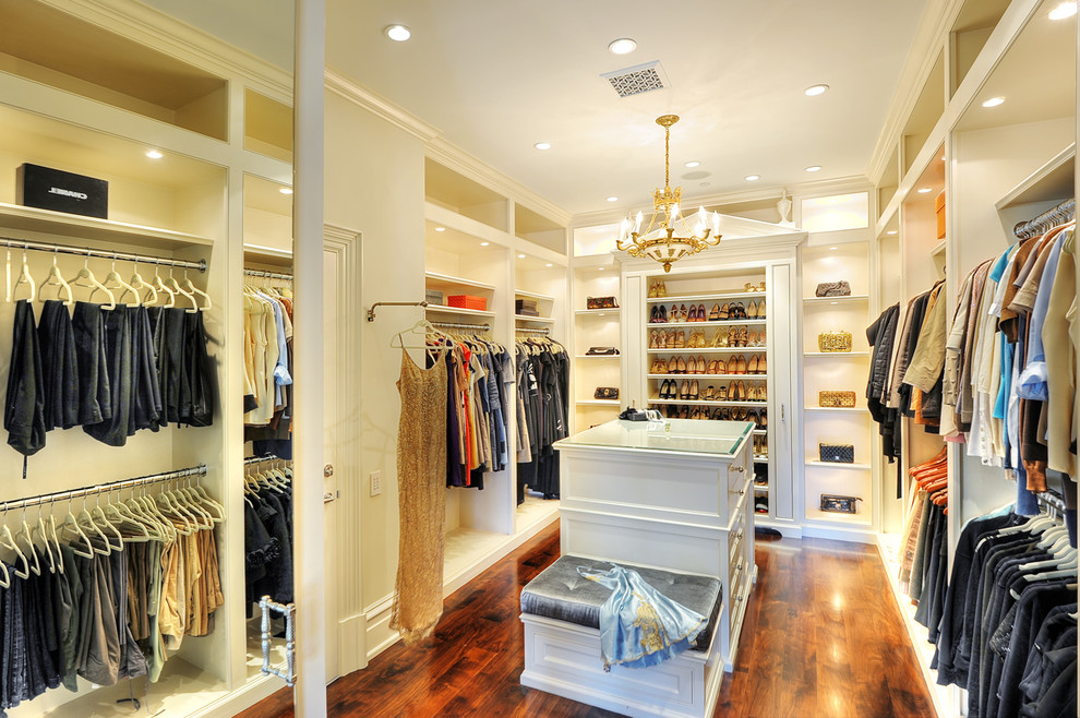 Ejemplo de armario vestidor unisex tradicional grande con armarios abiertos, puertas de armario blancas y suelo de madera oscura