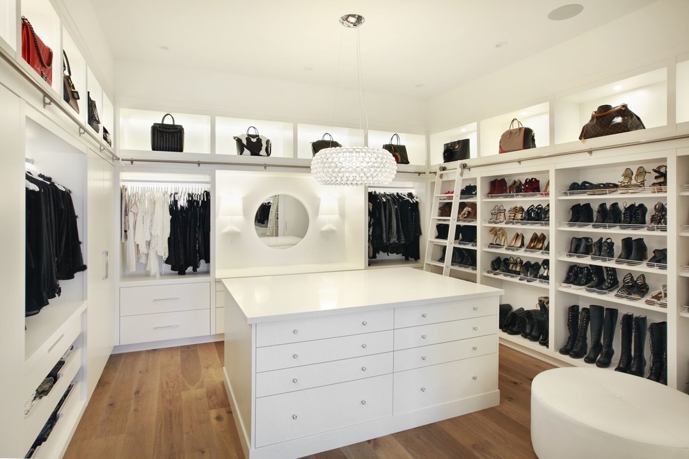 Modelo de armario vestidor unisex actual extra grande con armarios con paneles lisos, puertas de armario blancas y suelo de madera clara