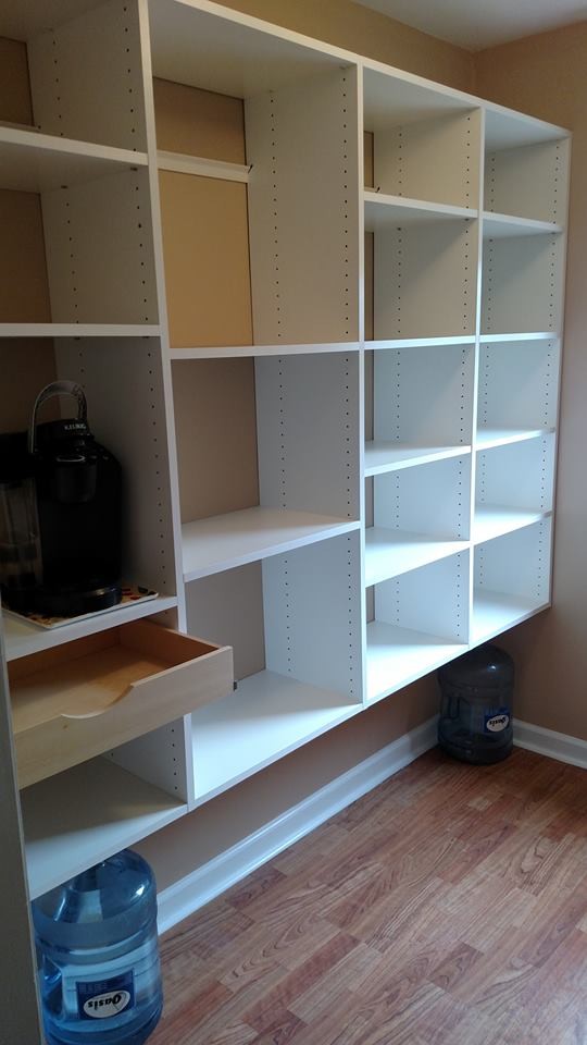 Photo of a large contemporary gender neutral walk-in wardrobe in Other with white cabinets and medium hardwood flooring.