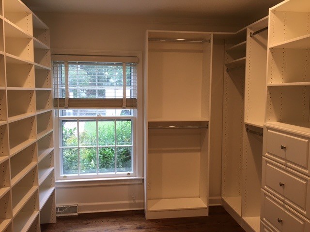 Large elegant gender-neutral medium tone wood floor and brown floor walk-in closet photo in Other with raised-panel cabinets and white cabinets