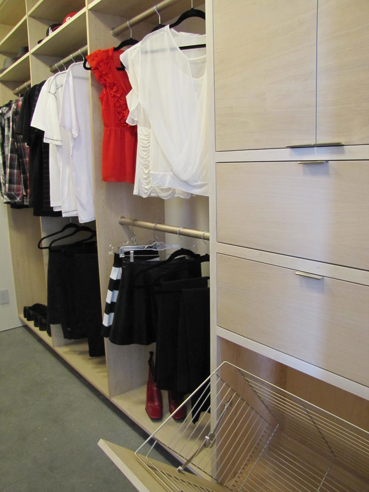 Design ideas for a medium sized contemporary gender neutral walk-in wardrobe in San Francisco with flat-panel cabinets, light wood cabinets and concrete flooring.