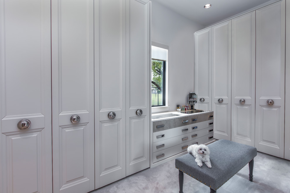 This is an example of a contemporary walk-in wardrobe for women in Dallas with recessed-panel cabinets, white cabinets and carpet.
