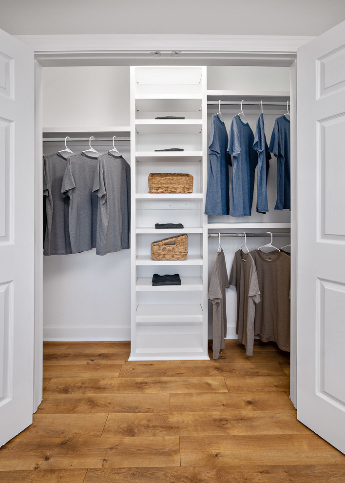 Ejemplo de armario unisex tradicional de tamaño medio con suelo laminado, suelo marrón, armarios abiertos y puertas de armario blancas