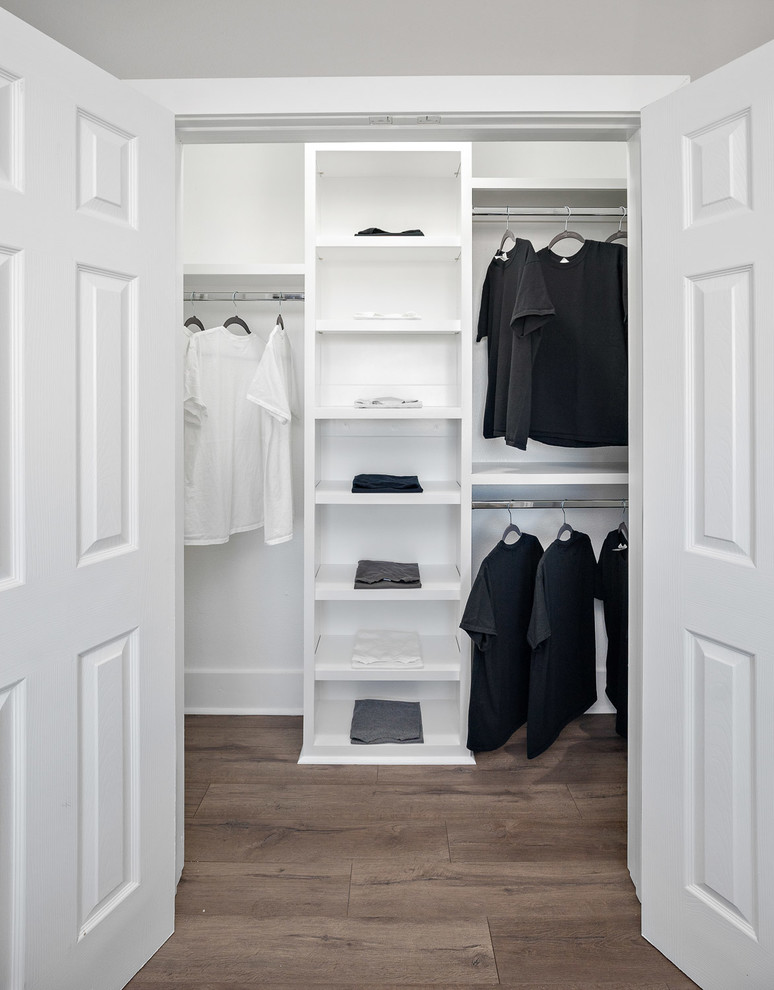 Idée de décoration pour un placard dressing minimaliste de taille moyenne et neutre avec des portes de placard blanches, sol en stratifié et un sol gris.