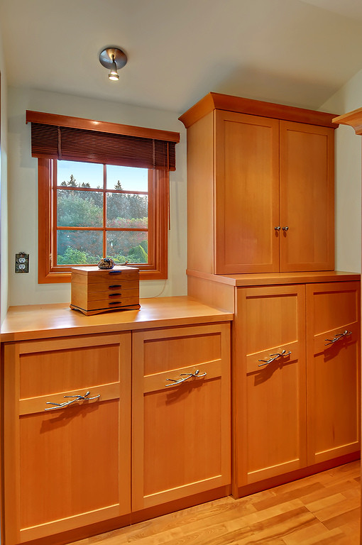 Inspiration for a small eclectic gender-neutral light wood floor dressing room remodel in Seattle with recessed-panel cabinets and light wood cabinets