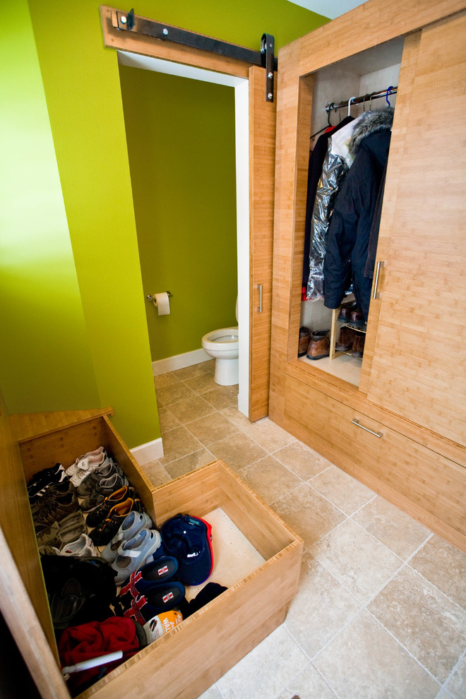 Cette photo montre un dressing et rangement tendance en bois clair avec un placard à porte plane et un sol en carrelage de céramique.