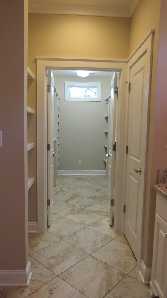 Large traditional gender neutral walk-in wardrobe in Charlotte with open cabinets, beige cabinets and porcelain flooring.