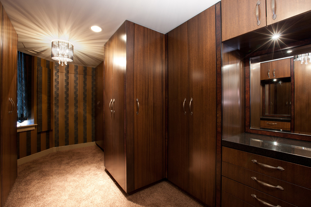 Example of a huge eclectic gender-neutral carpeted and brown floor dressing room design in Houston with flat-panel cabinets and dark wood cabinets