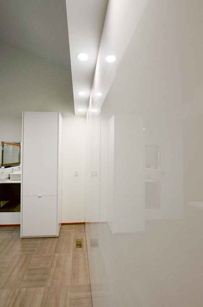 Cette photo montre un grand dressing room tendance avec un placard à porte plane, des portes de placard blanches et moquette.