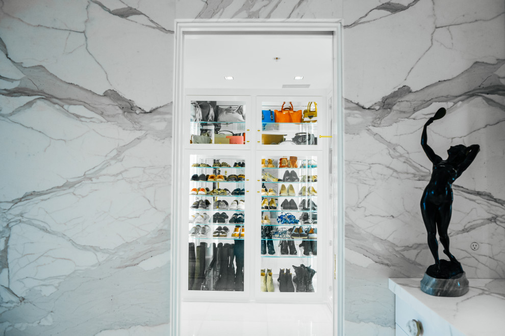 Foto de armario vestidor unisex actual de tamaño medio con armarios con paneles lisos, puertas de armario blancas, suelo de mármol y suelo blanco