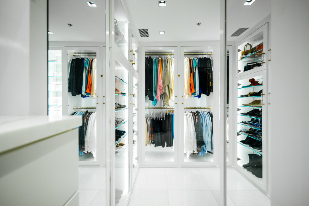Modelo de armario vestidor unisex actual de tamaño medio con armarios con paneles lisos, puertas de armario blancas, suelo de mármol y suelo blanco