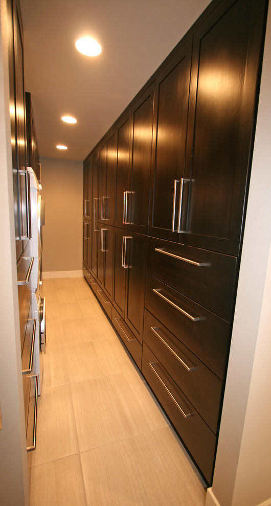 Inspiration for a mid-sized contemporary gender-neutral porcelain tile walk-in closet remodel in Seattle with shaker cabinets and dark wood cabinets