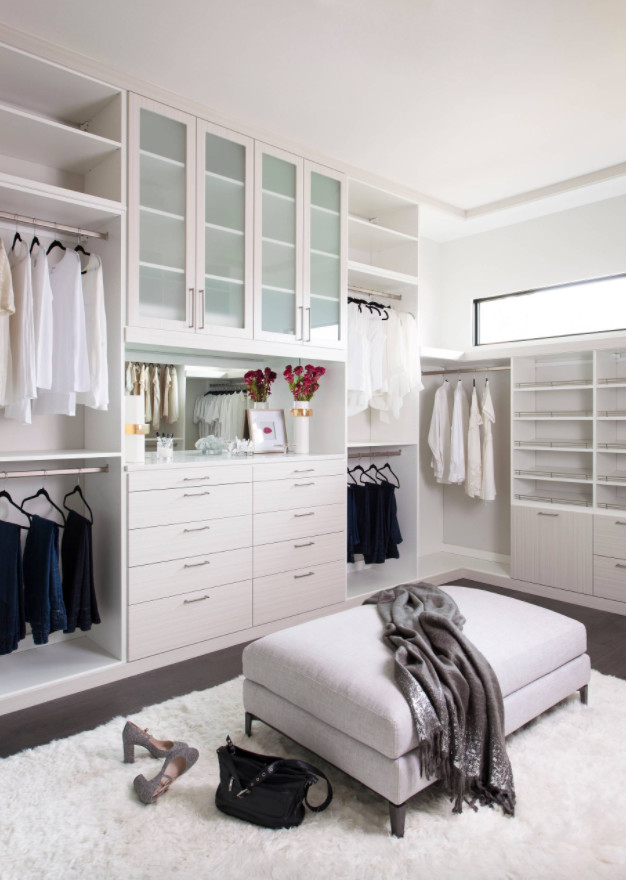 На фото: большая гардеробная комната унисекс в современном стиле с белыми фасадами и коричневым полом с