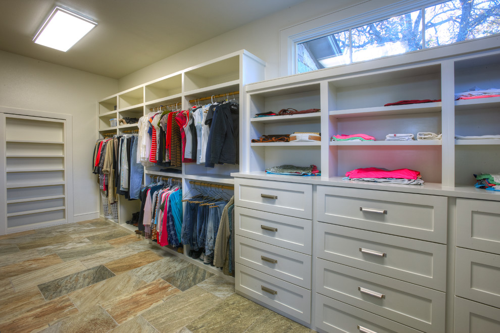 Photo of a large contemporary gender neutral dressing room in Austin with shaker cabinets, beige cabinets and slate flooring.