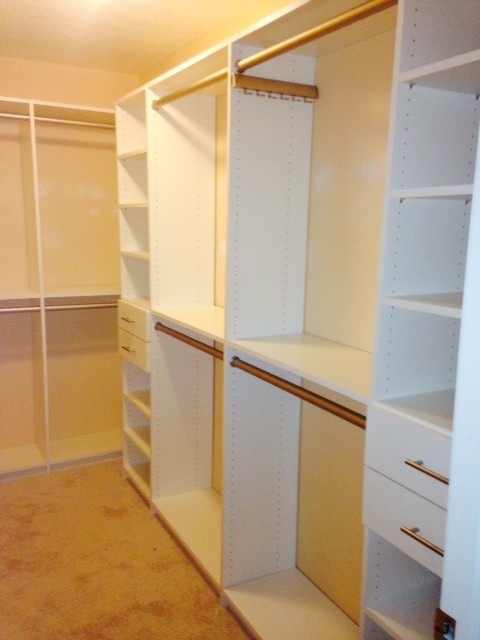 Ejemplo de armario vestidor unisex moderno de tamaño medio con armarios con paneles con relieve, puertas de armario beige y suelo de madera oscura