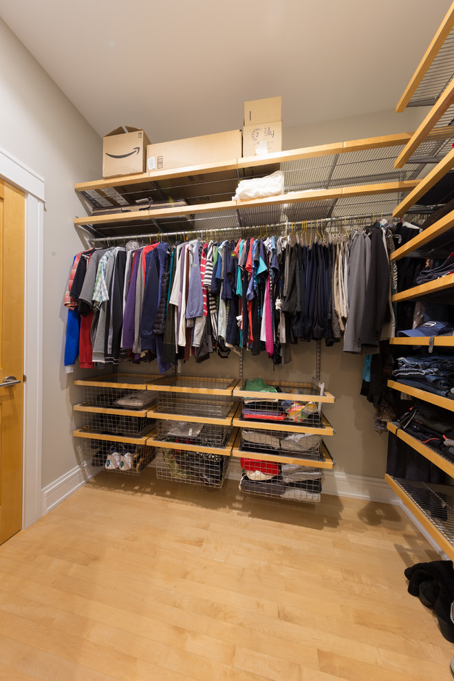 Imagen de armario vestidor unisex clásico de tamaño medio con armarios abiertos, puertas de armario de madera clara y suelo de madera en tonos medios