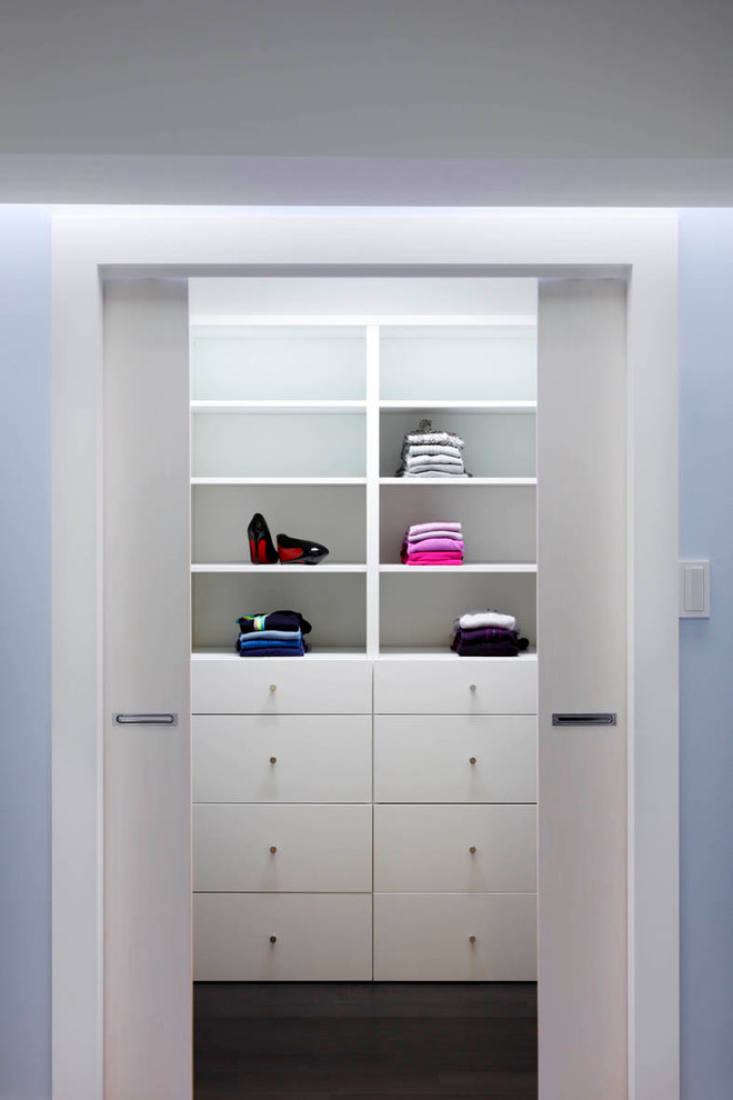 Modelo de armario vestidor unisex contemporáneo de tamaño medio con armarios con paneles lisos, puertas de armario blancas y moqueta