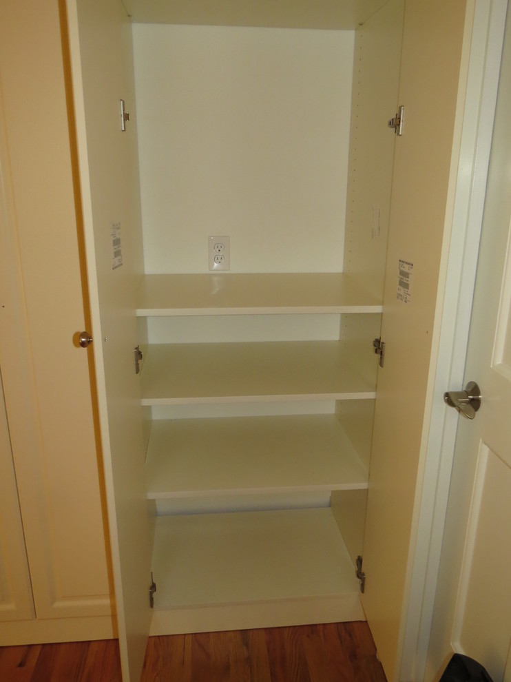 Ejemplo de vestidor unisex campestre de tamaño medio con armarios con paneles con relieve, puertas de armario blancas y suelo de madera oscura