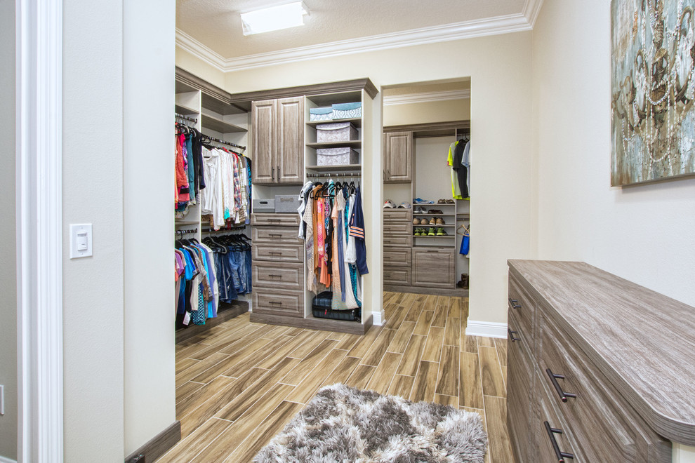 Foto de armario vestidor tradicional renovado grande con armarios con paneles con relieve, puertas de armario grises y suelo de madera en tonos medios