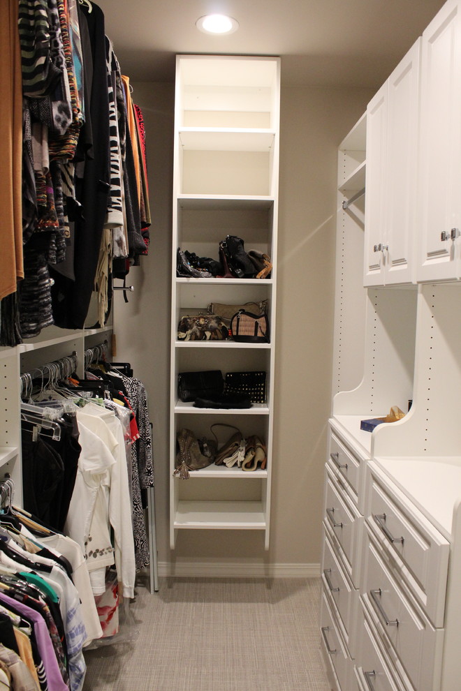 Example of a mid-sized minimalist women's carpeted walk-in closet design in New Orleans with open cabinets and white cabinets
