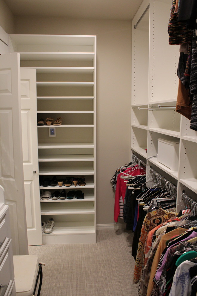 Medium sized modern walk-in wardrobe for women in New Orleans with open cabinets, white cabinets and carpet.