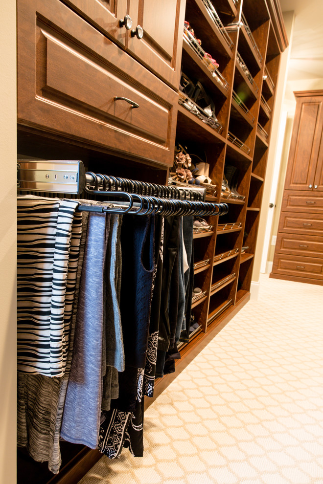 Diseño de vestidor unisex clásico grande con armarios con paneles con relieve, moqueta, puertas de armario de madera en tonos medios y suelo beige
