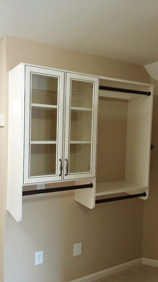 Foto di una cabina armadio unisex classica di medie dimensioni con ante di vetro, moquette, ante bianche e pavimento beige
