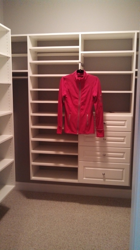 Ejemplo de armario vestidor unisex actual de tamaño medio con armarios con paneles con relieve, puertas de armario blancas y moqueta