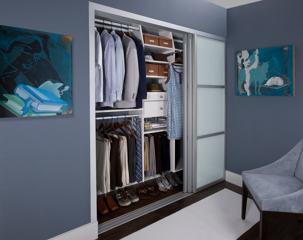 Photo of a medium sized modern gender neutral standard wardrobe in New York with dark hardwood flooring and white cabinets.