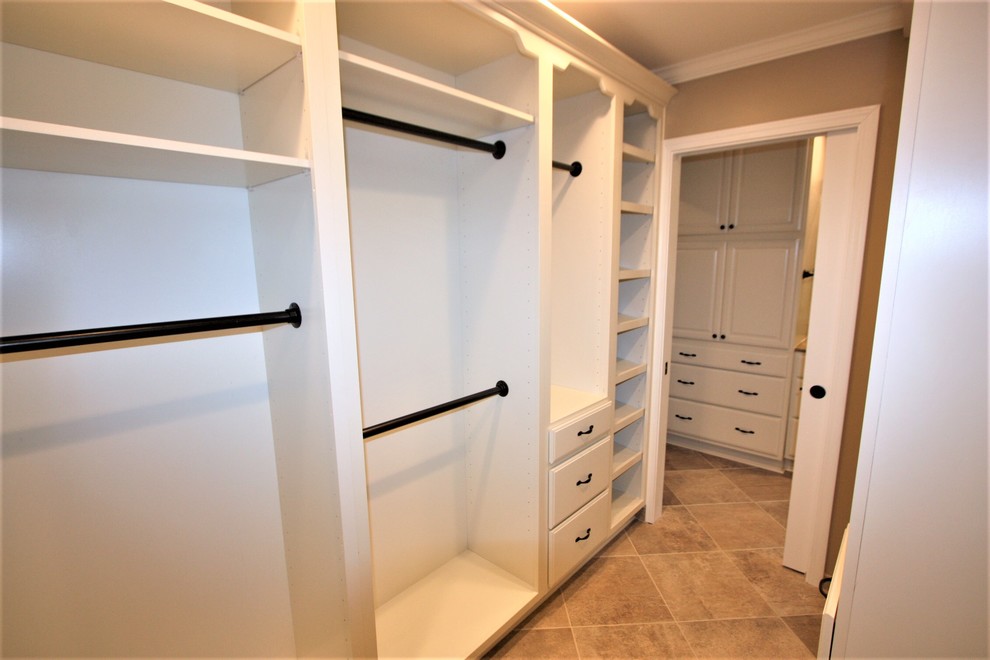 Imagen de armario y vestidor tradicional grande con armarios con paneles con relieve, puertas de armario blancas y suelo de baldosas de porcelana