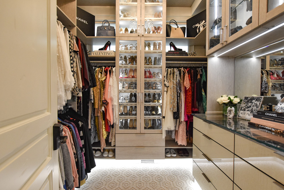 Mid-sized transitional women's carpeted and gray floor walk-in closet photo in Detroit with glass-front cabinets and light wood cabinets