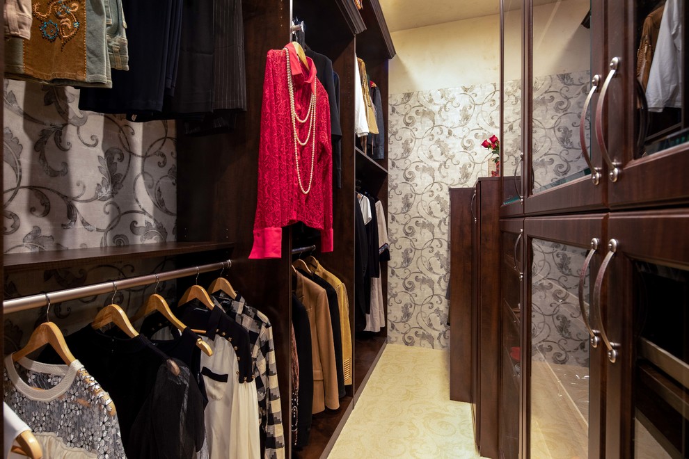 Ejemplo de armario vestidor unisex tradicional de tamaño medio con armarios tipo vitrina, puertas de armario de madera en tonos medios, moqueta y suelo beige