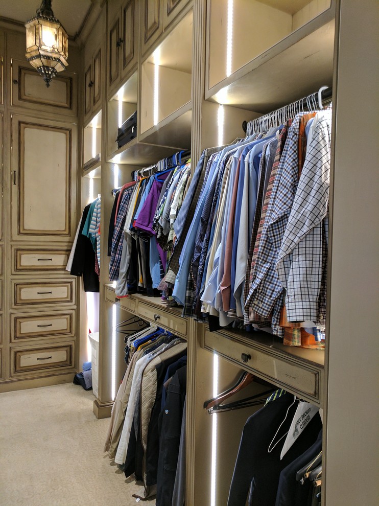 Imagen de armario vestidor de hombre clásico de tamaño medio con armarios con paneles con relieve, puertas de armario con efecto envejecido, moqueta y suelo beige