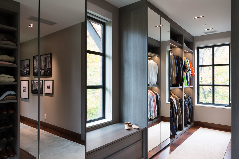 Идея дизайна: огромная гардеробная комната в современном стиле с плоскими фасадами, фасадами цвета дерева среднего тона, ковровым покрытием и бежевым полом для мужчин