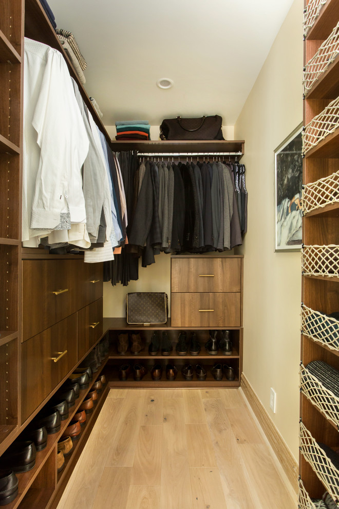 Imagen de armario vestidor de hombre de tamaño medio con armarios con paneles lisos, puertas de armario de madera en tonos medios, suelo de madera clara y suelo beige