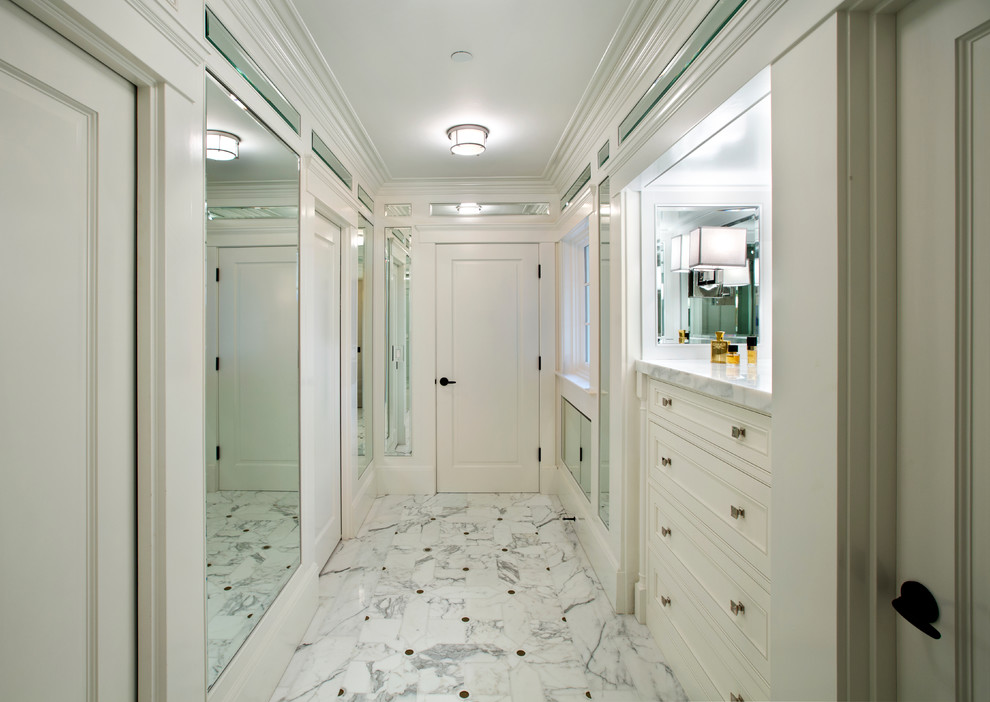 Photo of a mediterranean wardrobe in San Francisco with beaded cabinets, white cabinets and marble flooring.