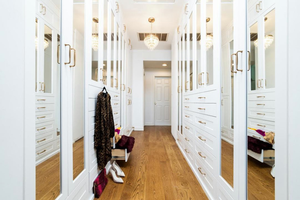 Inredning av ett klassiskt walk-in-closet, med skåp i shakerstil, vita skåp, mellanmörkt trägolv och brunt golv