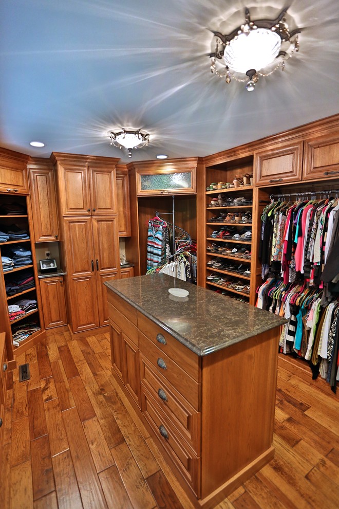 Design ideas for a large classic gender neutral walk-in wardrobe in Chicago with raised-panel cabinets, medium wood cabinets and medium hardwood flooring.